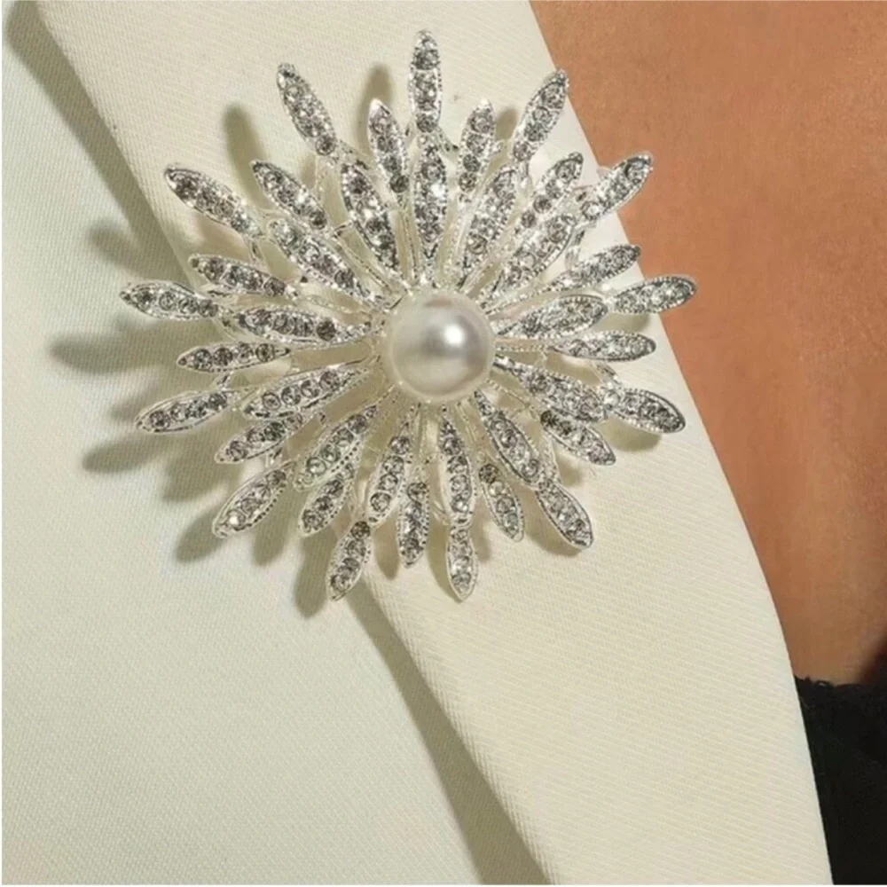 New silver-toned sunburst brooch clear rhinestones and a central faux pearl